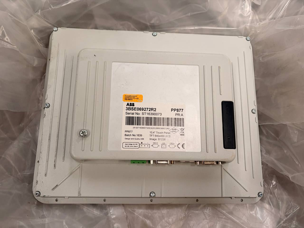 Back view of a metallic electronic device with labels on a clear background - ABB HMI