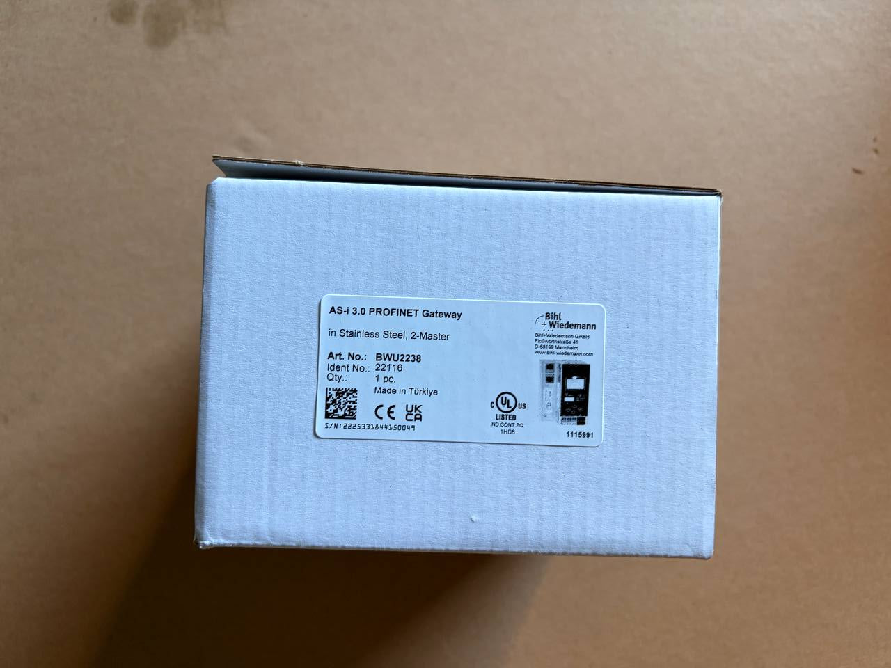 White electronic device packaging with labels on a brown surface