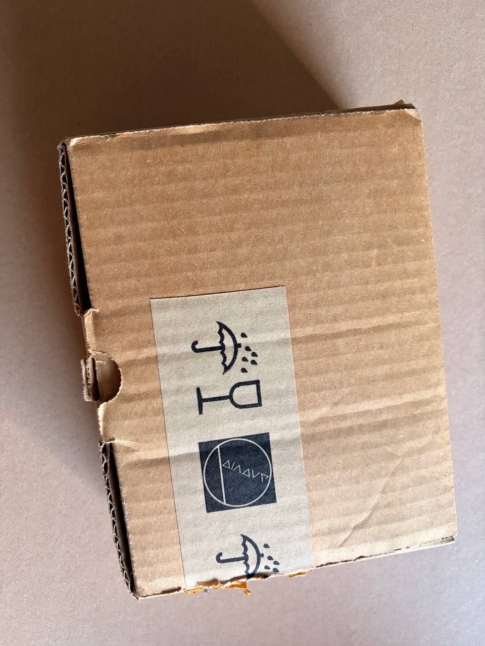 Cardboard box with a label featuring symbols on a beige background