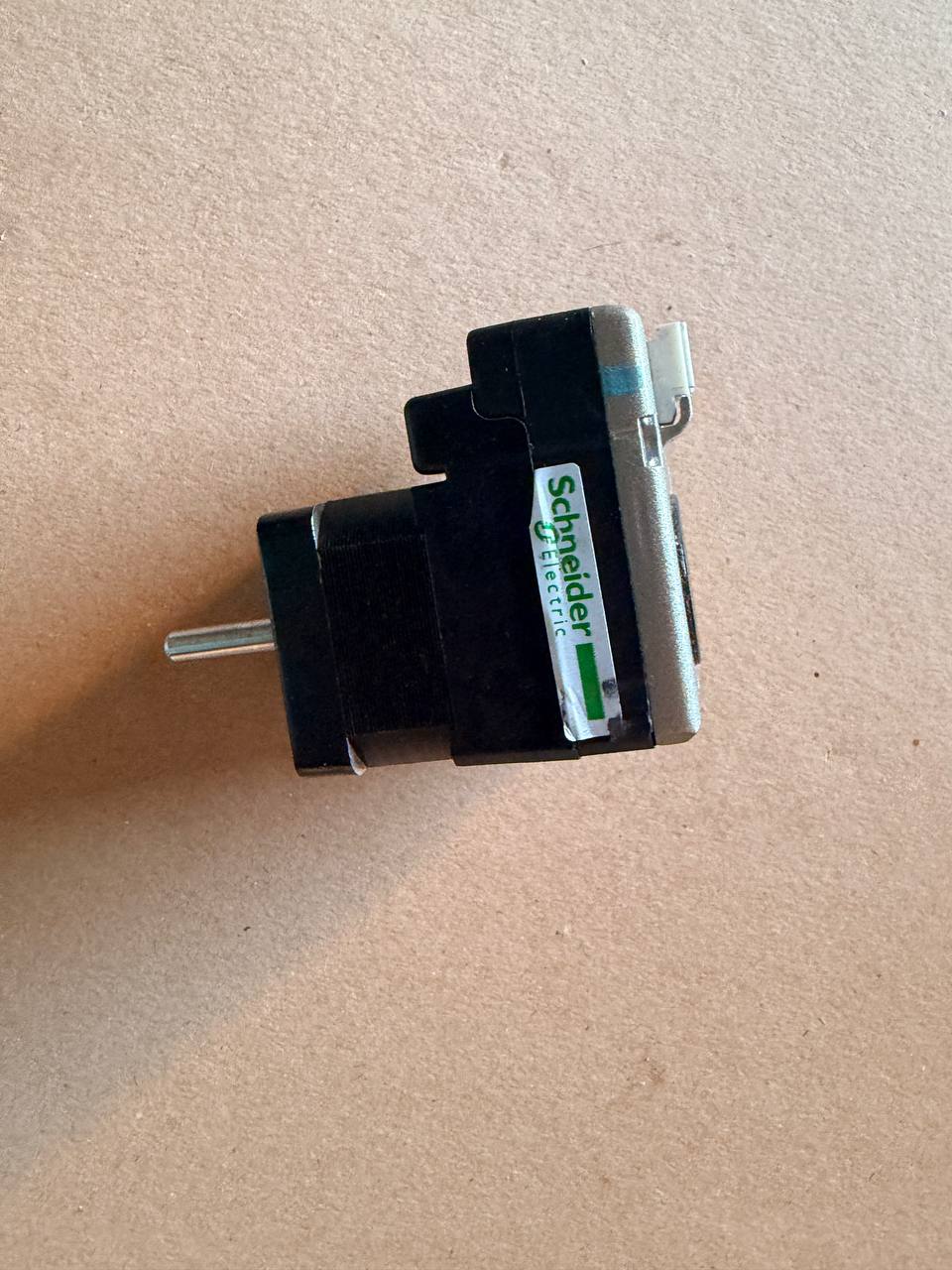 Black and silver schneider electrical plug on a beige background