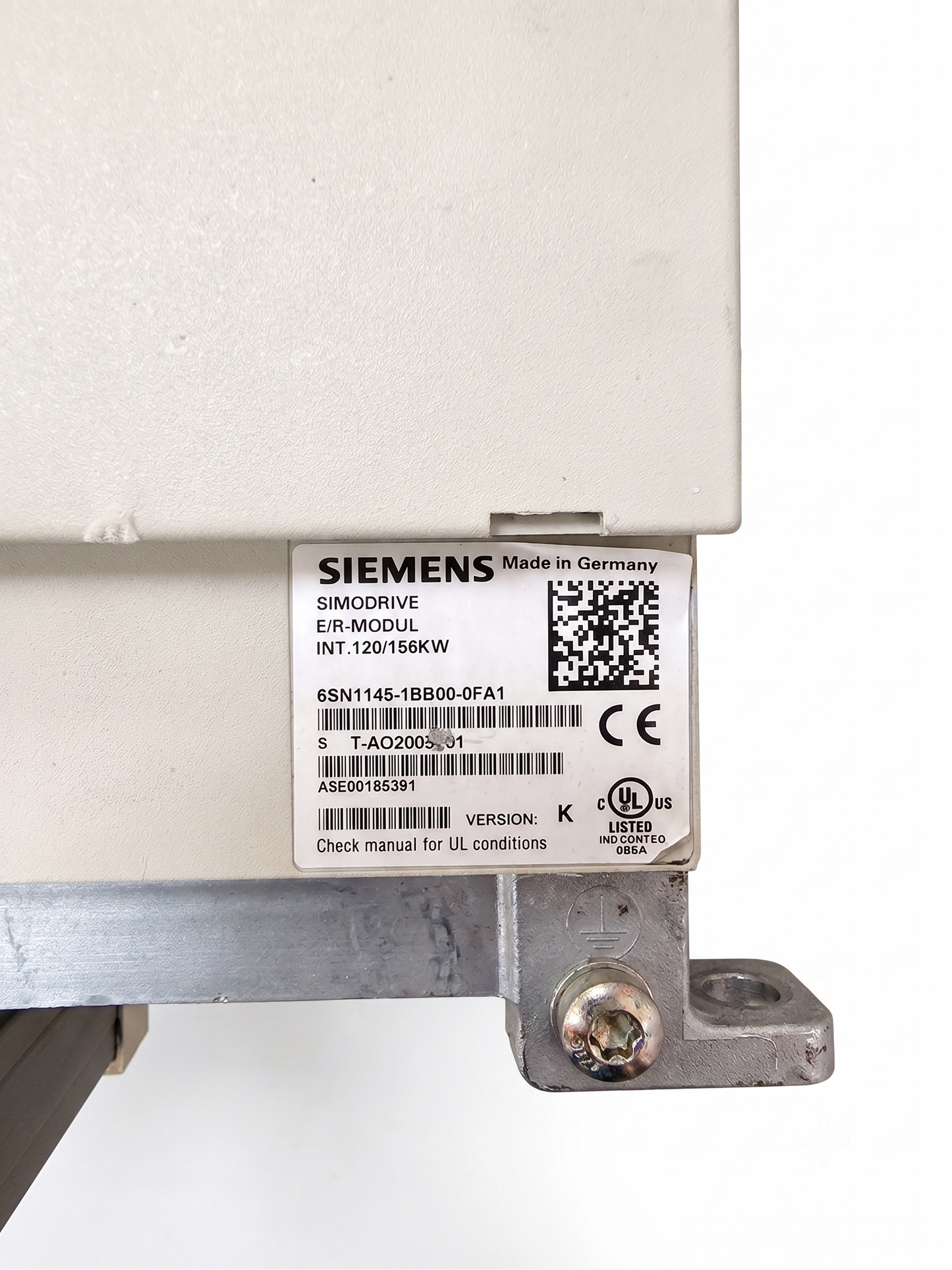 Close-up of a Siemens SimDrive E-Module label on a beige industrial electrical component, showing model details and barcodes.