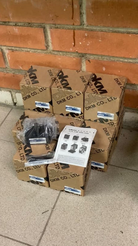 Stock of boxed DKM 7GBK18BMH gear heads, one unboxed with screws and manual