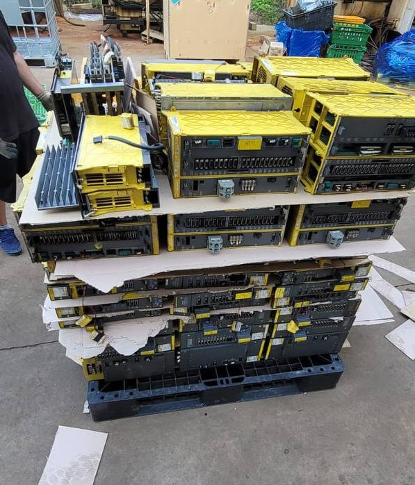 FANUC surplus lot: Stacked pallet of FANUC modules including larger spindle and power supply units