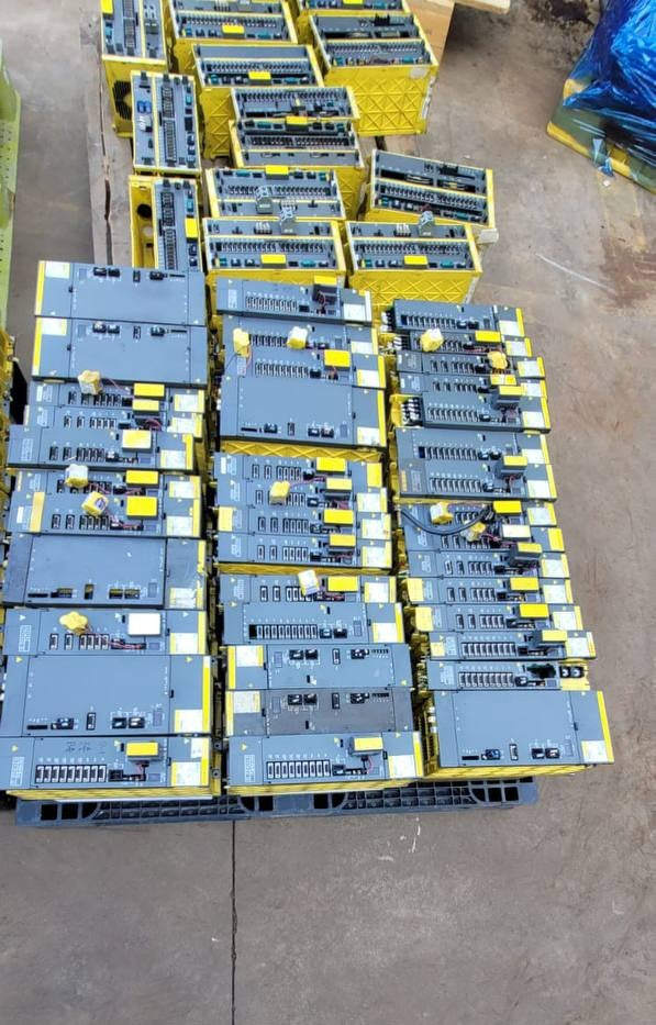 FANUC surplus lot: FANUC alpha amplifier modules stacked on a pallet, top view