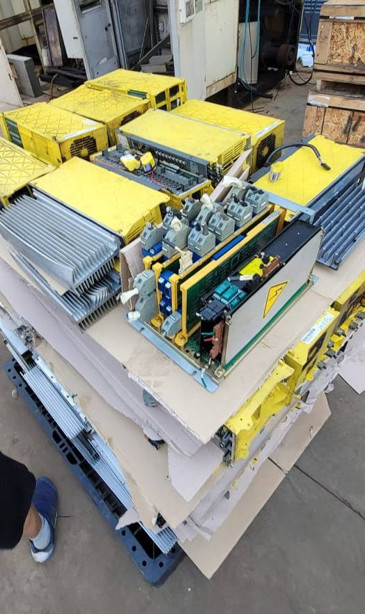 FANUC surplus lot: Mixed FANUC modules on a pallet, one with its cover removed