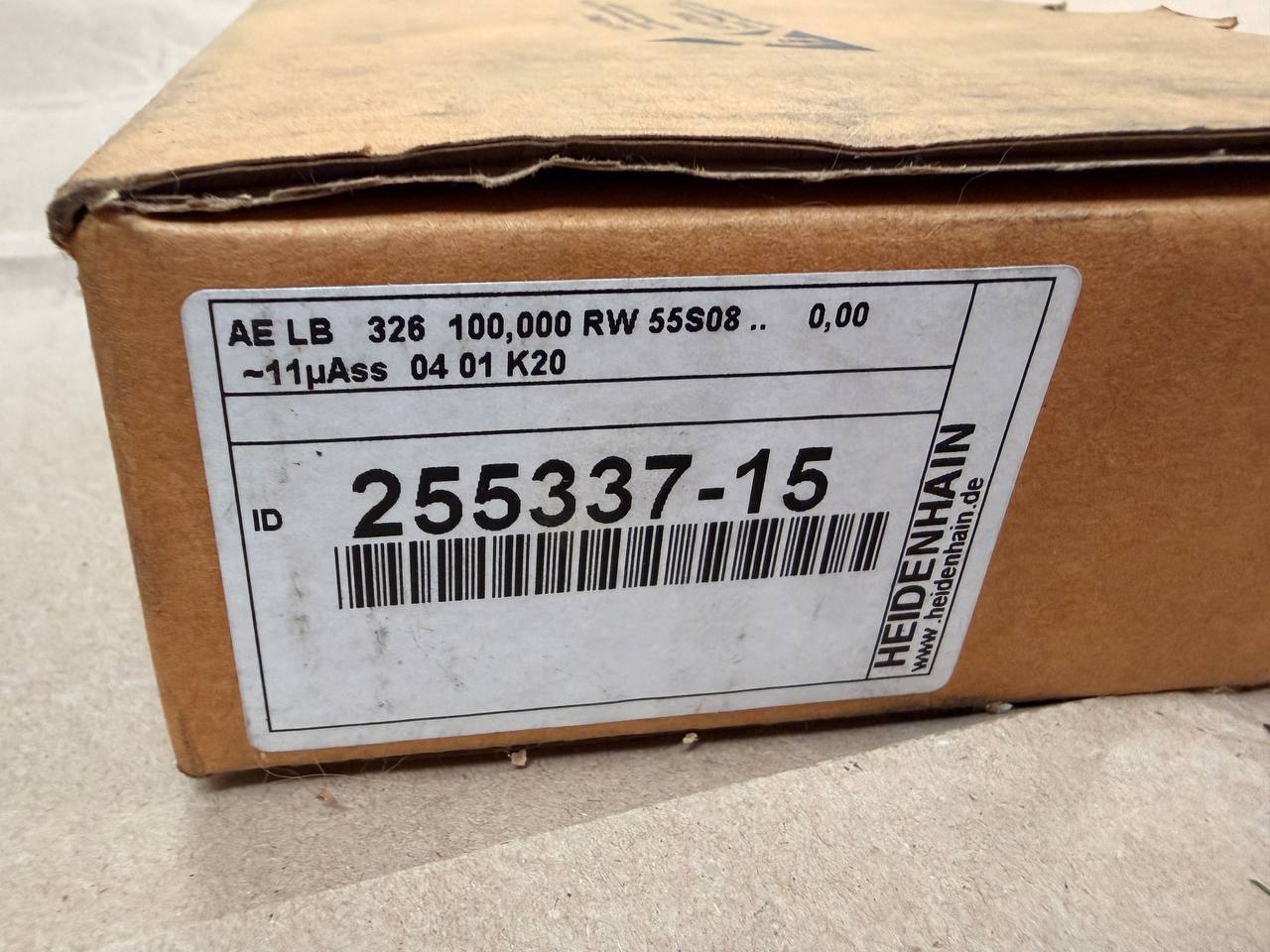 A close-up of a brown cardboard box with a large white product label. The label shows a barcode, the number 255337-15, and the brand name HEDENHAIN vertically on the right side.