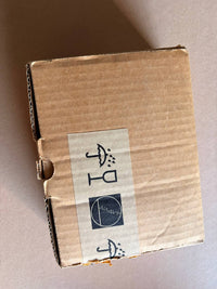 Cardboard box with a label featuring symbols on a beige background