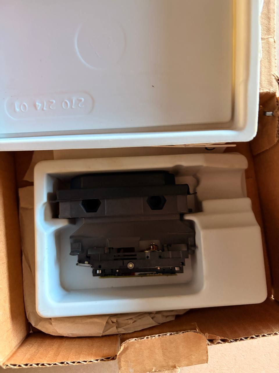 Heidenhain - Two black printer cartridges inside a white foam packaging tray on cardboard.
