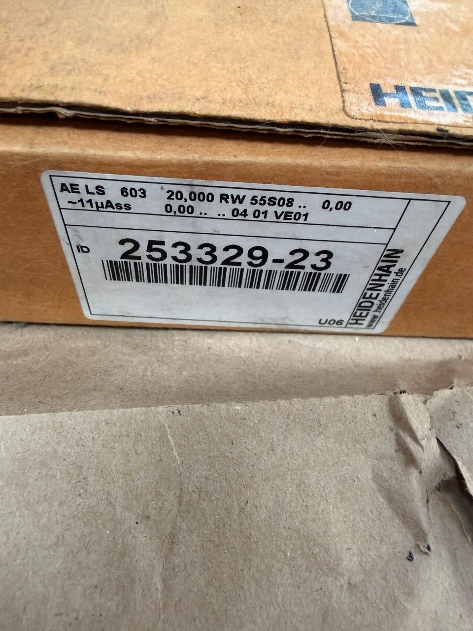 Cardboard box with a label featuring a barcode and text.