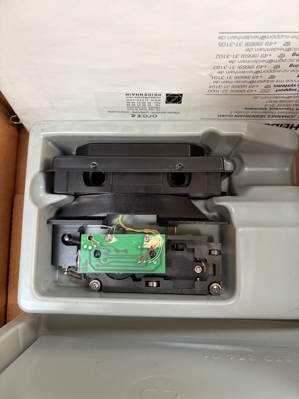 Electronic component inside a white plastic container with visible branding.