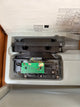 Electronic component inside a white plastic container with visible branding.