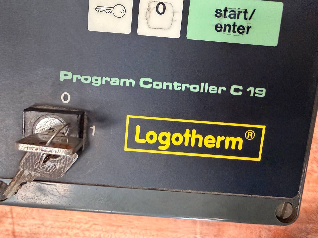 Logotherm program controller C19 with a key inserted on a wooden surface