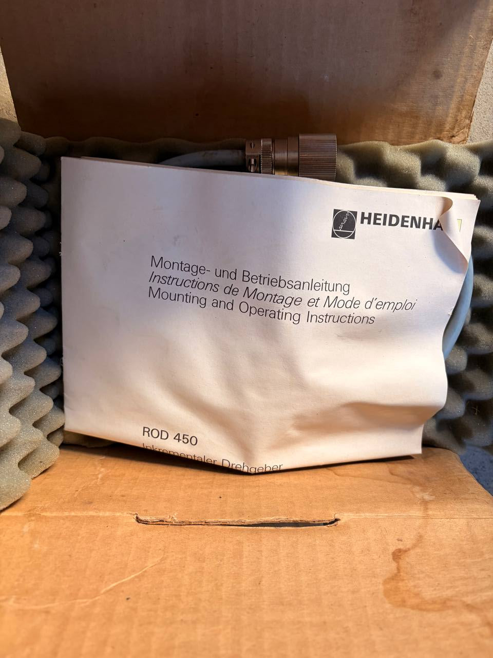 Heidenhain instruction manual on a foam surface with a cardboard box in the background