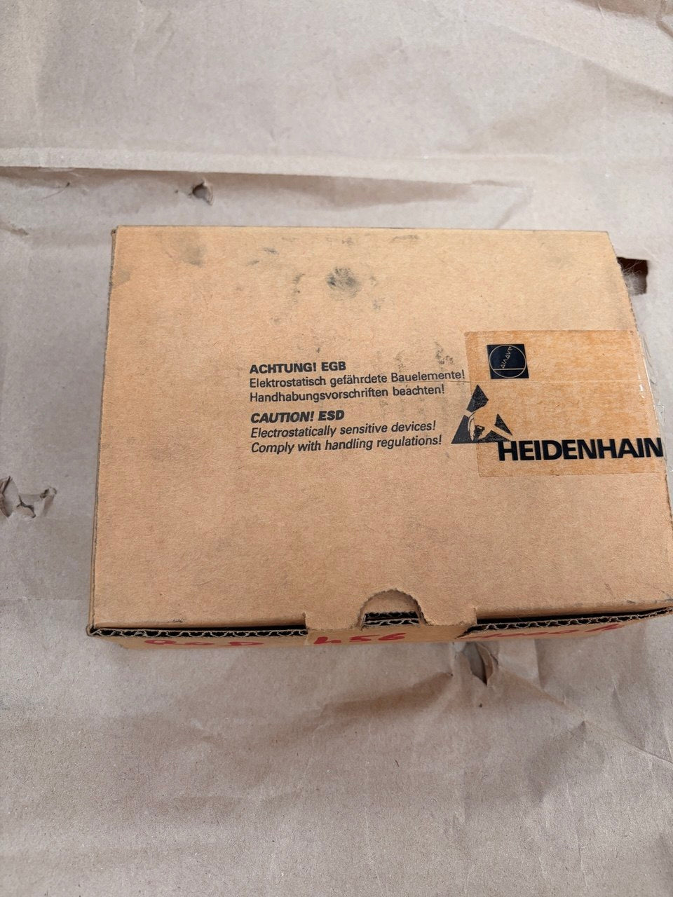 Cardboard box with Heidenhain branding on a light gray background