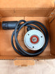 Mechanical component with black cable inside a cardboard box