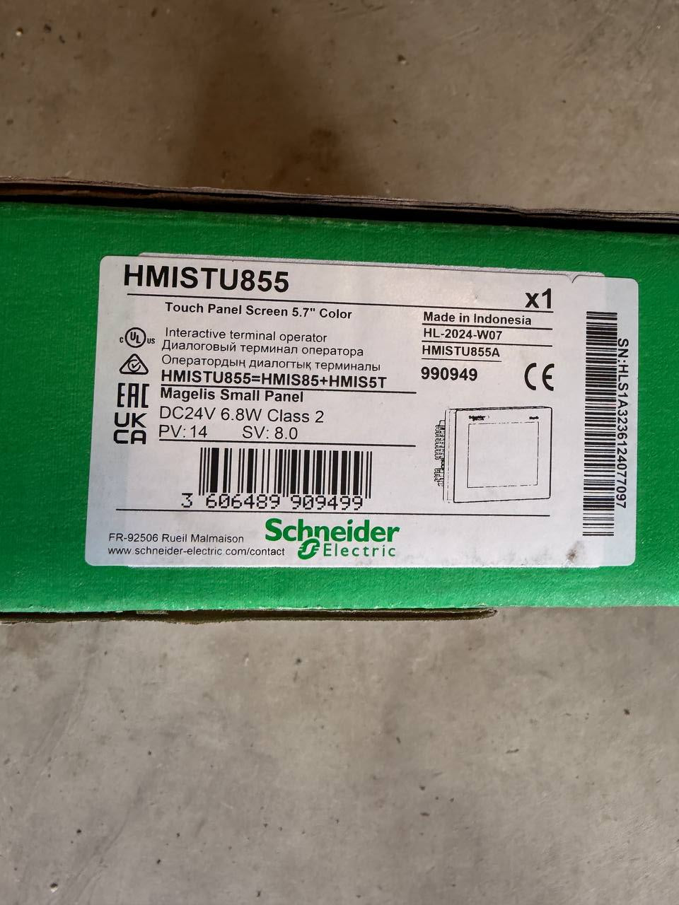 Green electrical box with Schneider Electric label on a concrete floor