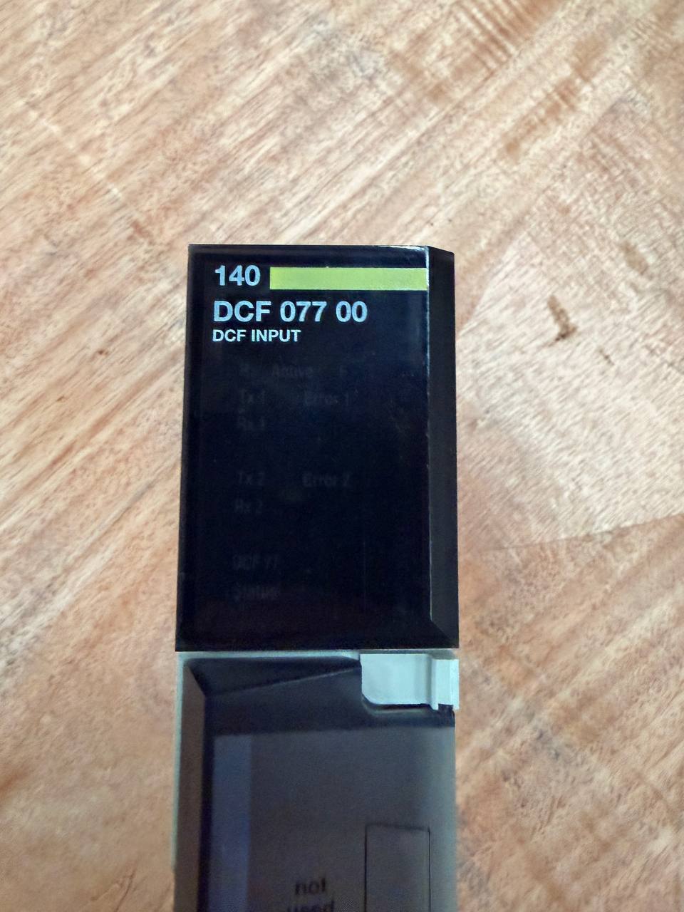 Black electronic device with digital display on a wooden surface