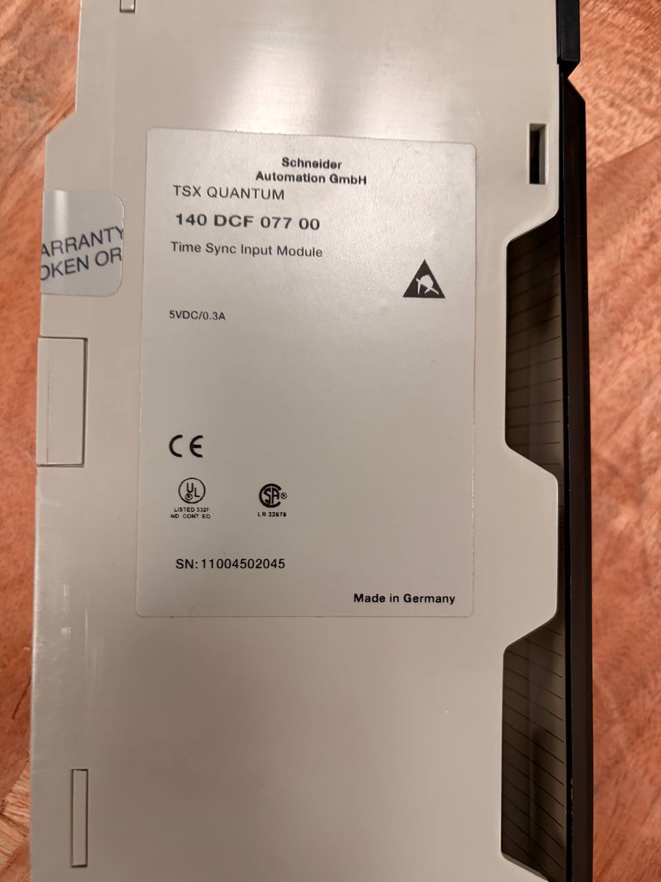 Time Sync Input Module with Schneider branding on a wooden surface