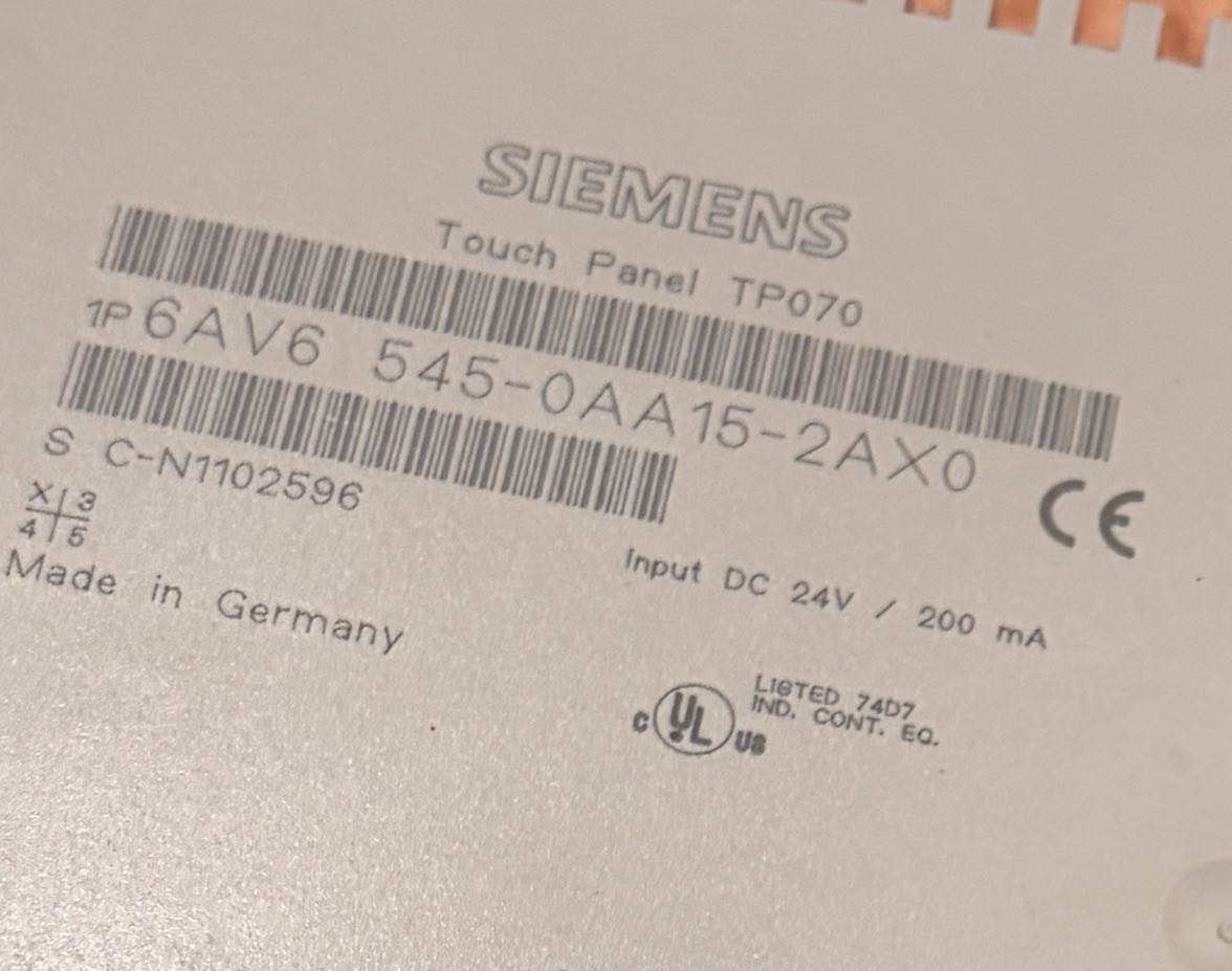 Siemens touch panel with label and certification logos on a metallic surface