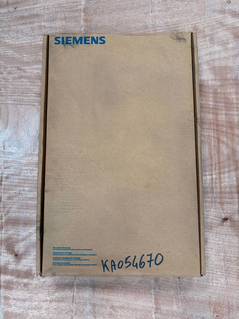 Cardboard box with Siemens branding on a wooden surface