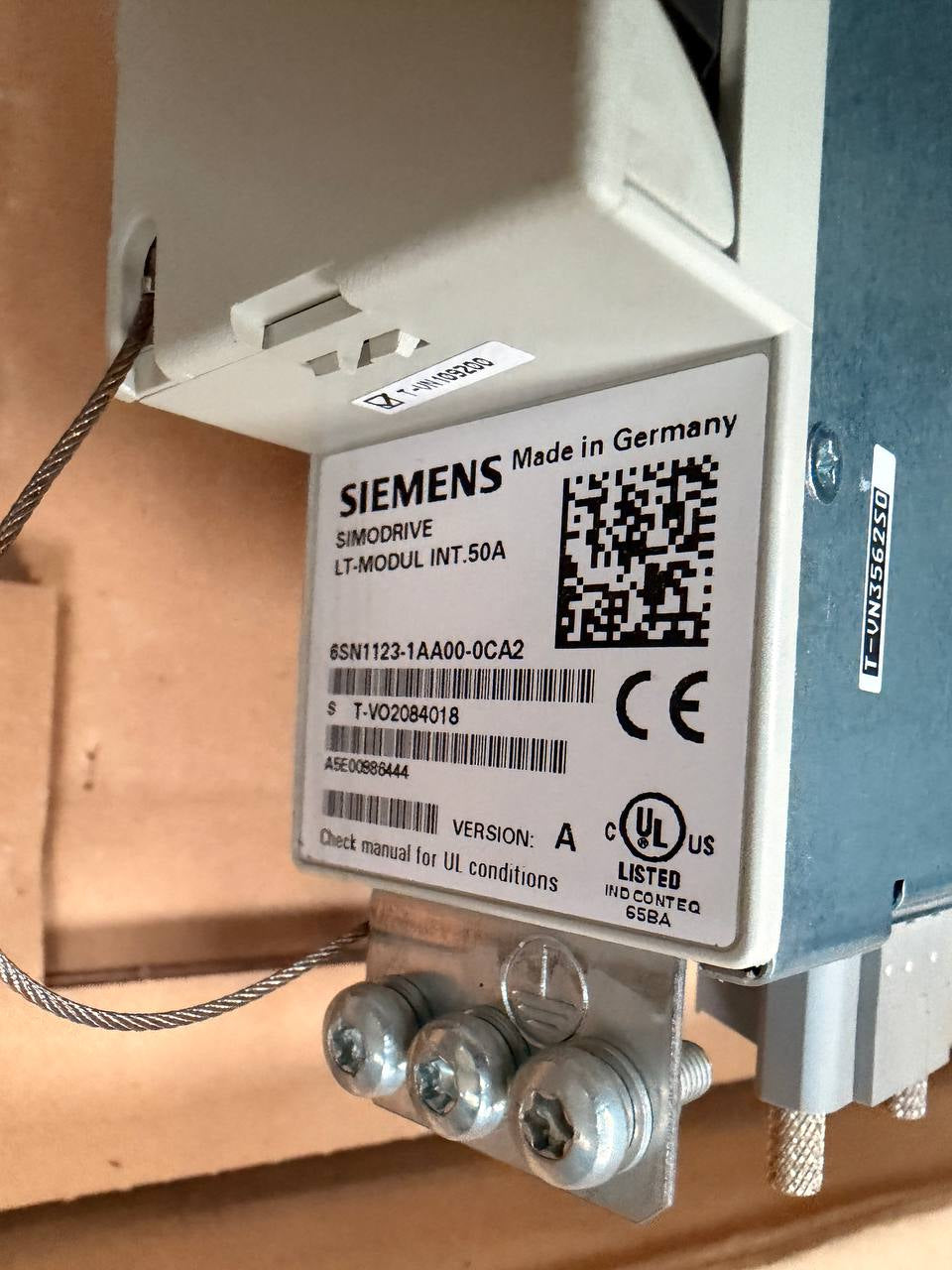 Electrical component with Siemens label and QR code on a wooden background