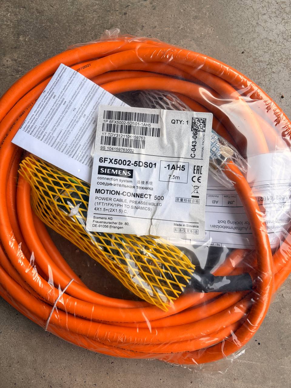 Orange Siemens cable with a label on a concrete surface