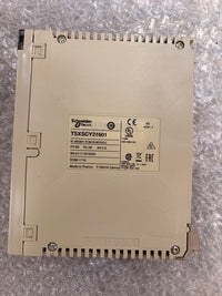Schneider Electric TSXSCY21601 industrial control module in beige plastic, showing the back with screw terminals and a central label with regulatory markings, placed on bubble wrap.