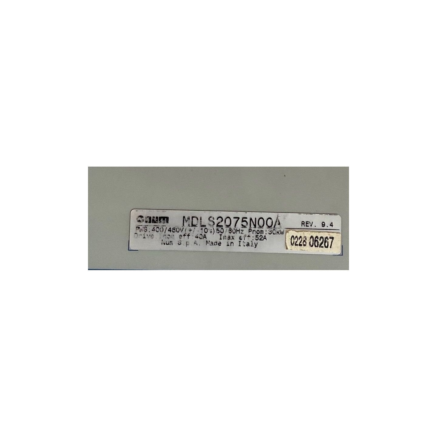 A NUM white rectangular product label with black printed text and a yellow serial sticker, placed on a gray background.